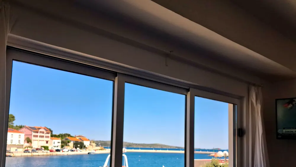 The living room window, looking out over the harbour and a moored boat